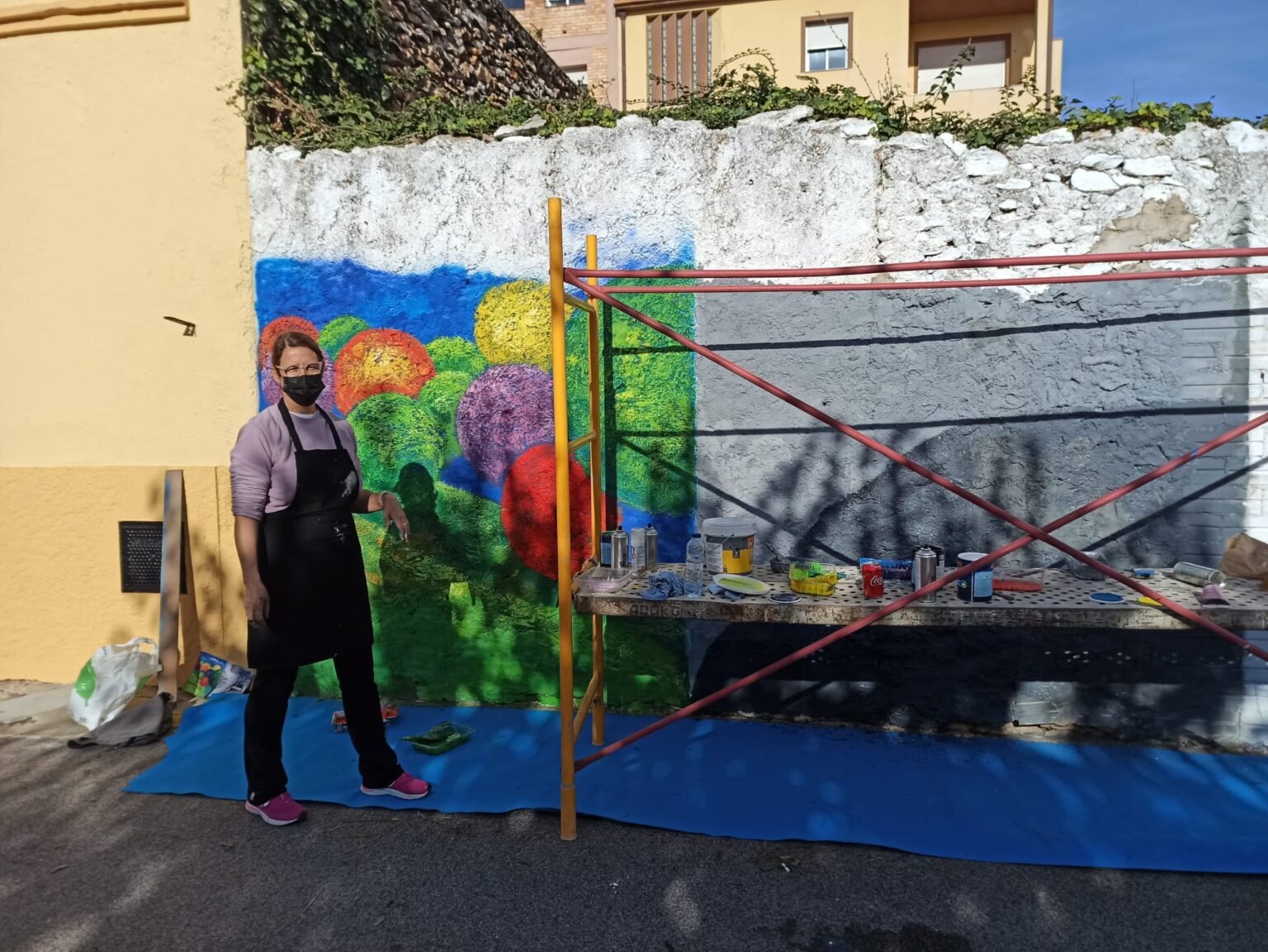 persona pintando un mural en el exterior